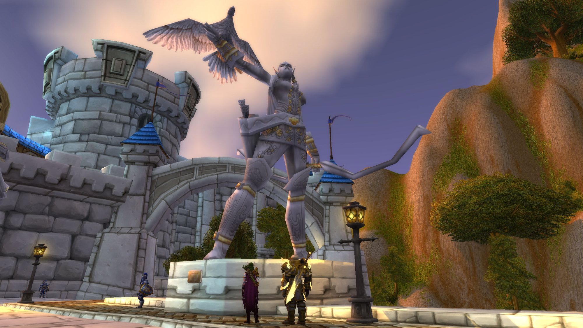 Alleria’s statue, bow raised and a bird on her arm, towers over the Valley of Heroes. Two small figures, one in gold plate, stand at the plinth.